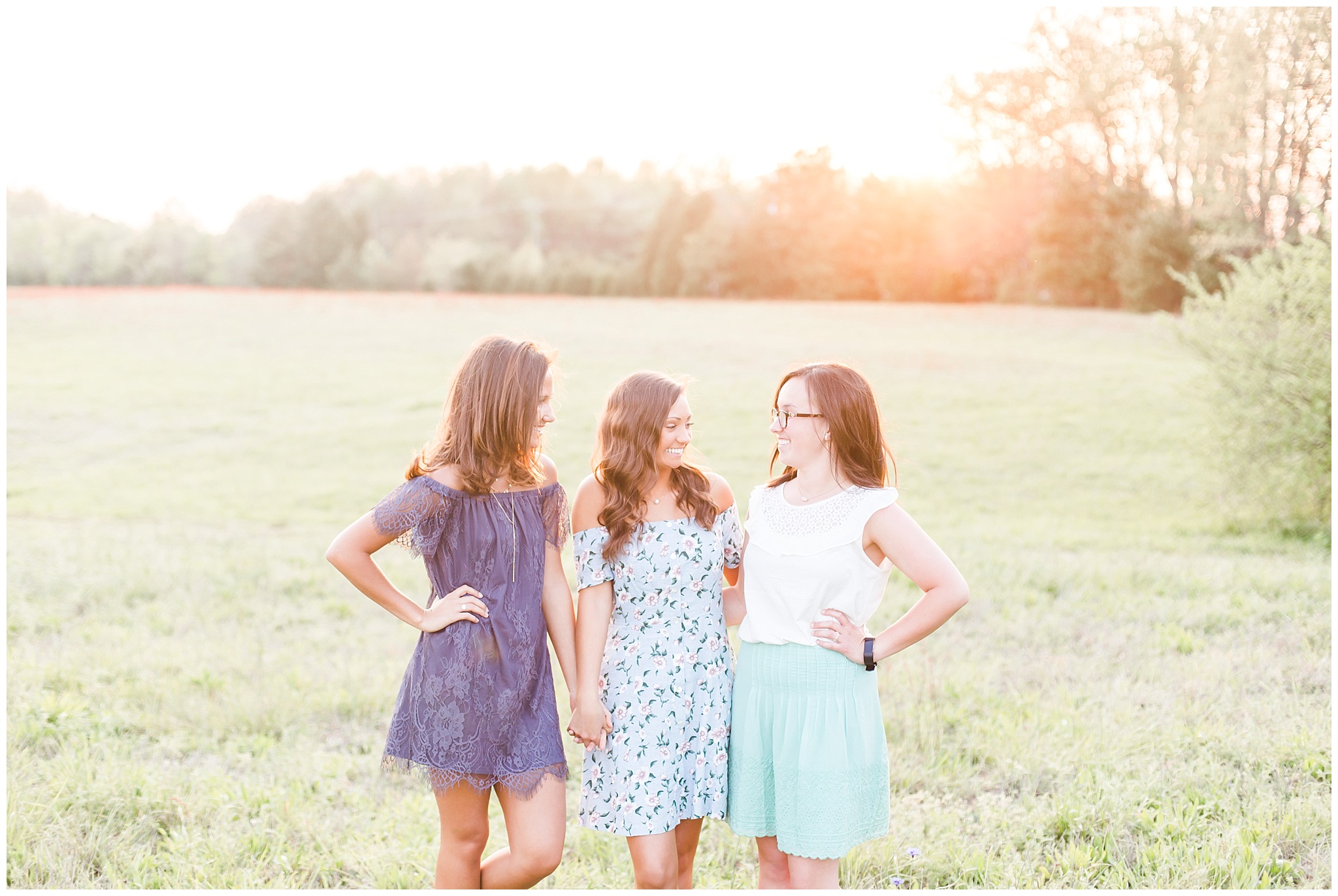 spring senior session with two sisters and a friend and their cap and gowns